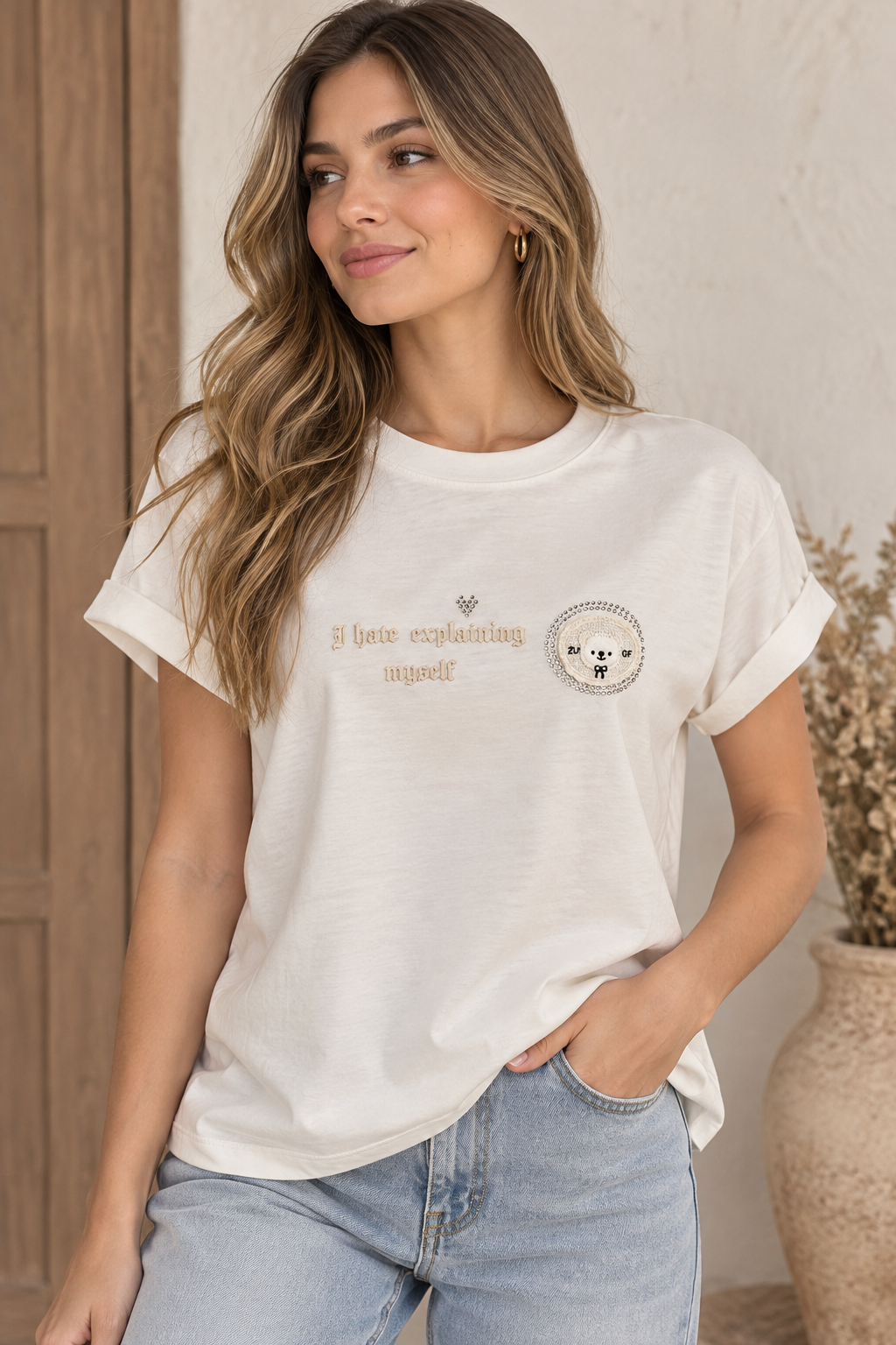 Camiseta marfil con detalles de piedras y aplique en manga 3100